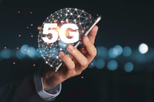 Mãos masculinas mexendo no celular que está com a conectividade 5G